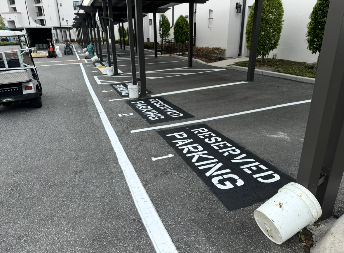 Reserved parking spaces marked in white on black signs beside a covered walkway.