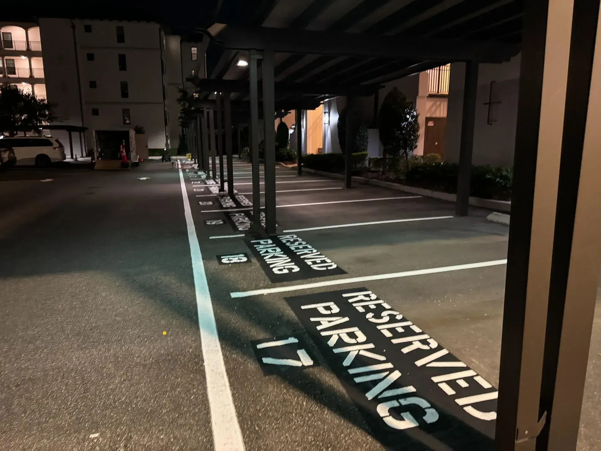 Reserved parking spaces marked on a dimly lit outdoor lot at night.