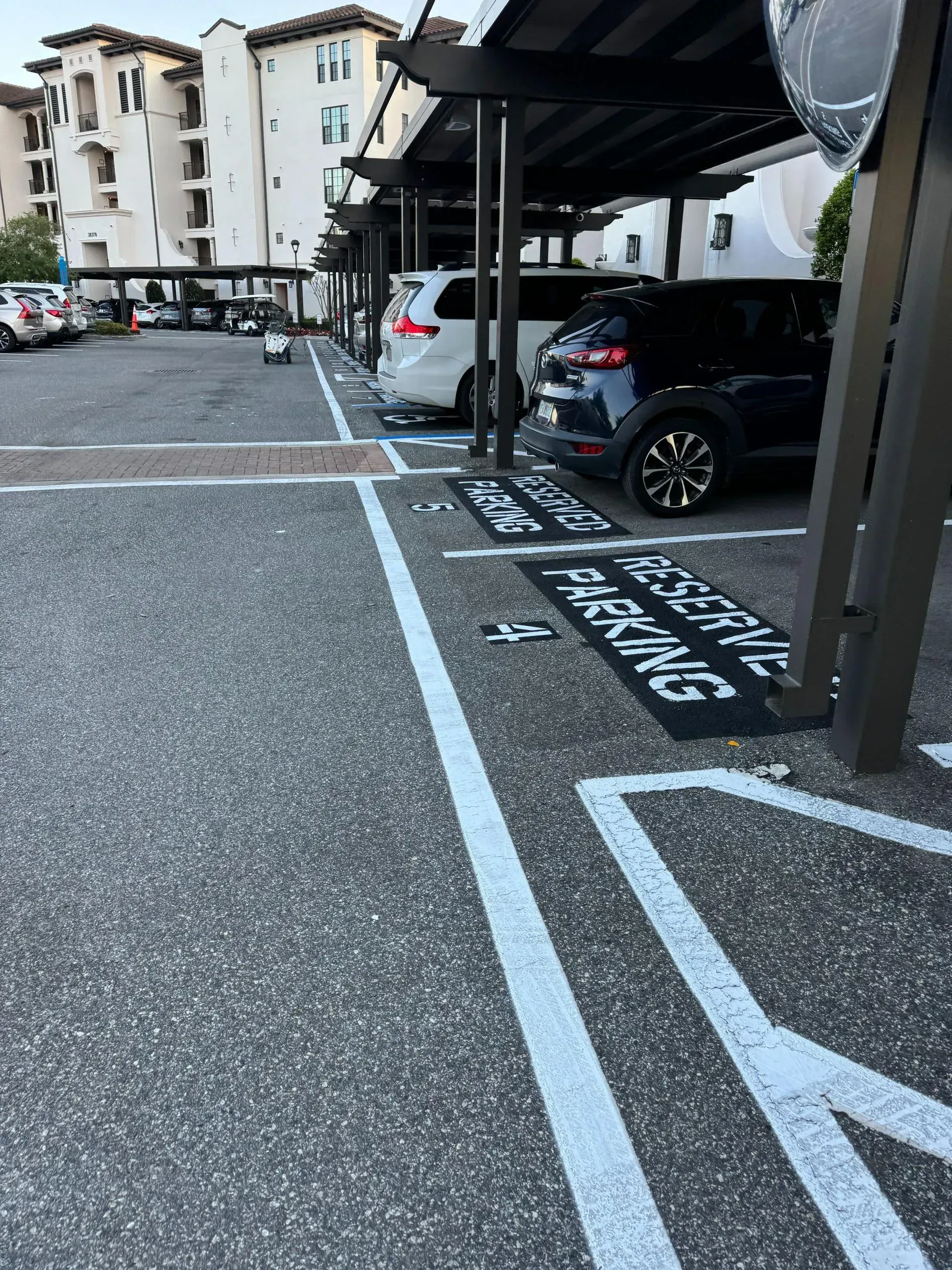 Accessible parking spaces in a hotel lot with parked cars and white painted markings