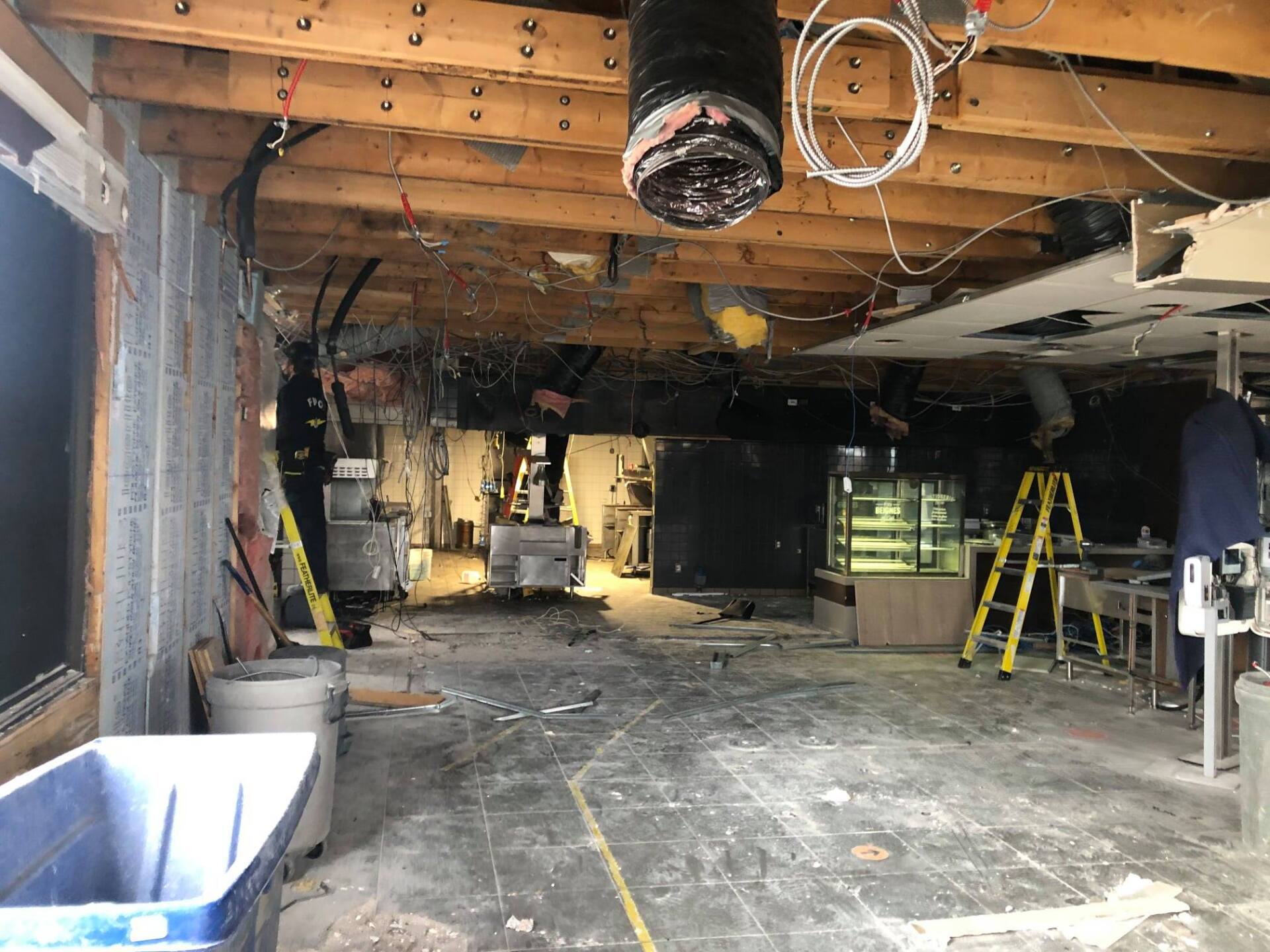 Une pièce vide avec une échelle et une poubelle à l'intérieur.