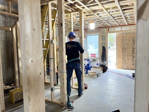 Un homme portant un casque se tient dans une pièce en construction.