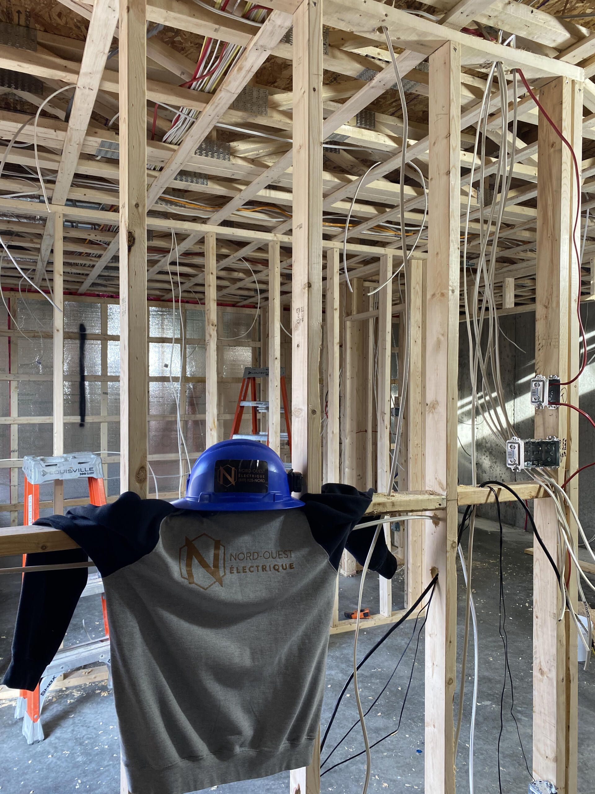 Un casque de sécurité est suspendu à un cadre en bois dans un bâtiment en construction.