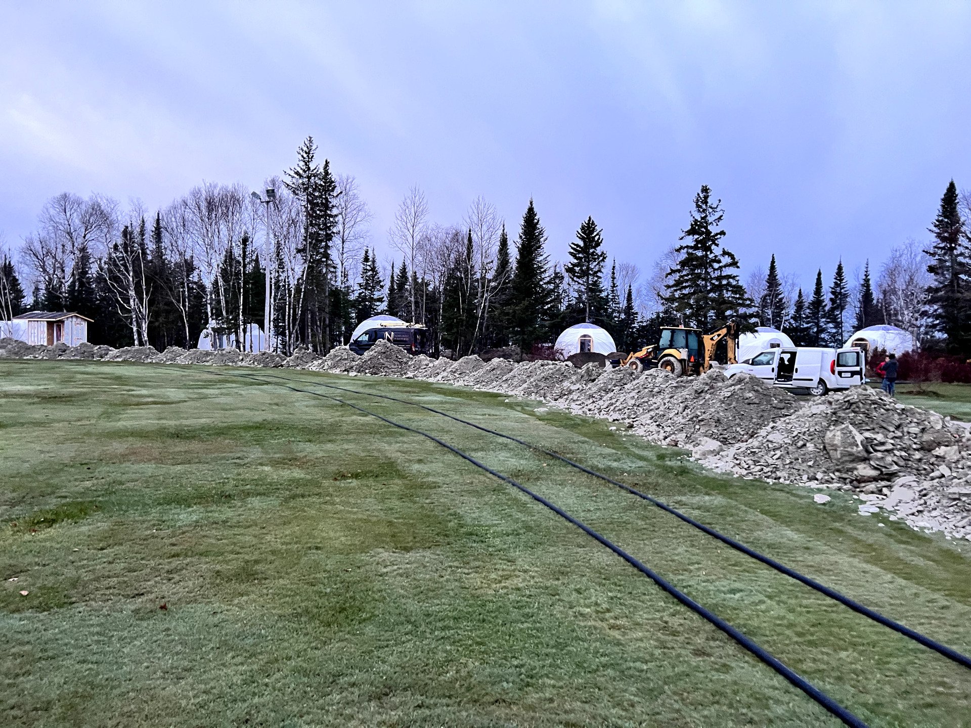 Un grand champ avec beaucoup de terre et d'arbres en arrière-plan.