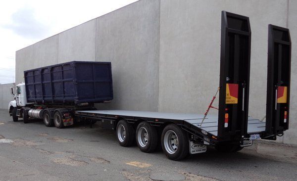 A Truck with A Flatbed Trailer Attached to It Is Parked in Front of A Building — Welshpool, WA — PTE Group Pty Ltd
