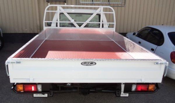 A White Truck with A Red Tray Is Parked Next to A Beautiful White Car — Welshpool, WA — PTE Group Pty Ltd