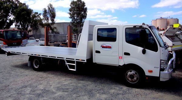 A White Flatbed Truck Is Parked in A Gravel Lot — Welshpool, WA — PTE Group Pty Ltd