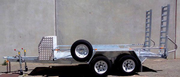 A Trailer with A Beautiful Ladder Attached to It Is Parked in Front of A Concrete Wall — Welshpool, WA — PTE Group Pty Ltd