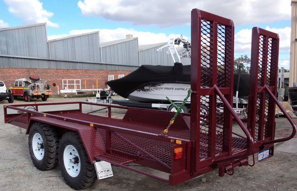 A Red Trailer Is Parked Next to A Boat in A Parking Lot — Welshpool, WA — PTE Group Pty Ltd
