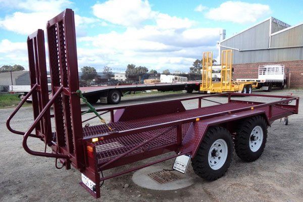 A Red Trailer Is Parked Next to A Yellow Trailer in A Parking Lot — Welshpool, WA — PTE Group Pty Ltd