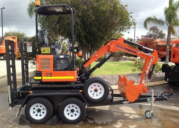 A Small Orange Excavator Is Parked on A Trailer — Welshpool, WA — PTE Group Pty Ltd