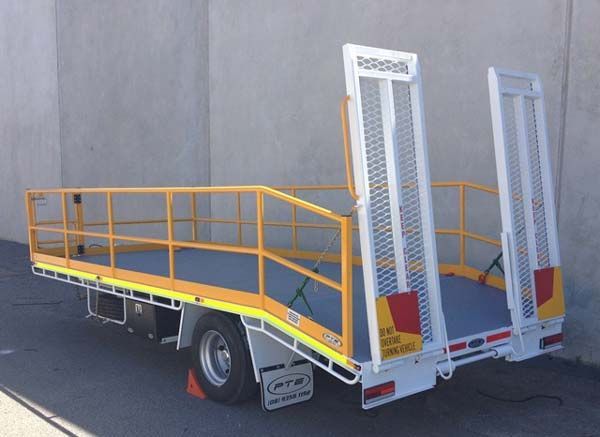 A Flatbed Truck with A Ramp Attached to It Is Parked on The Side of The Road — Welshpool, WA — PTE Group Pty Ltd
