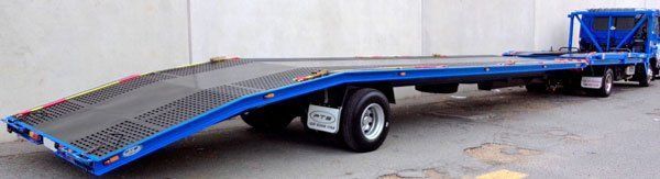 A Blue Tow Truck with A Flat Bed Is Parked on The Side of The Road — Welshpool, WA — PTE Group Pty Ltd