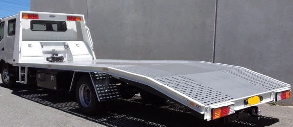 A Tow Truck with A Flat Bed Is Parked in Front of A Building — Welshpool, WA — PTE Group Pty Ltd