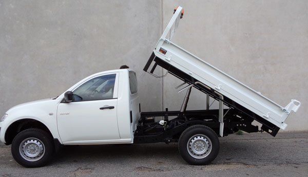 A White Dump Truck with The Bed up Is Parked in Front of A Building — Welshpool, WA — PTE Group Pty Ltd
