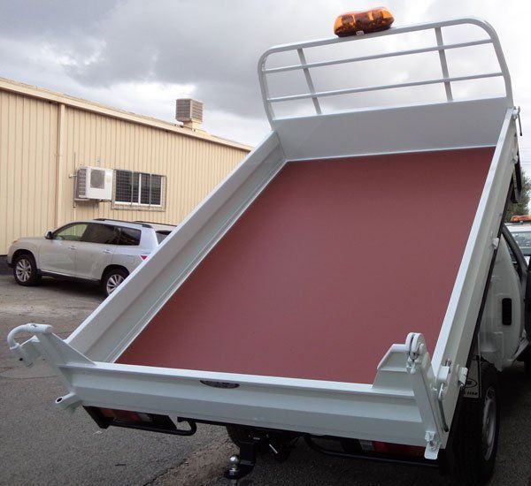 A White Dump Truck with A Red Floor Is Parked in Front of A Building — Welshpool, WA — PTE Group Pty Ltd