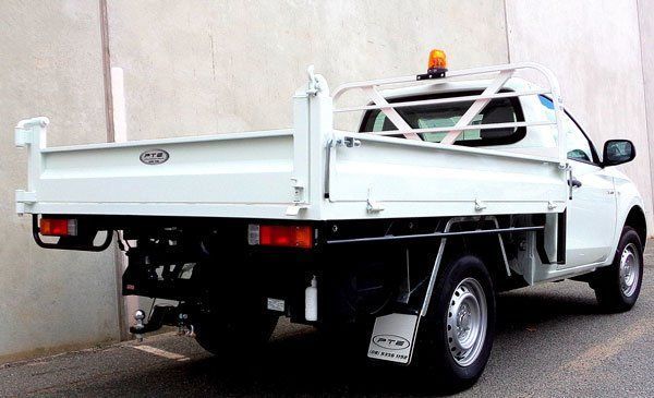 A White Truck with A Dump Bed Is Parked in Front of A Building — Welshpool, WA — PTE Group Pty Ltd