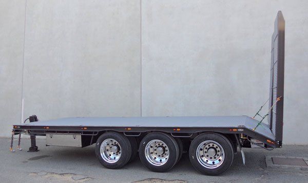 A Flatbed Trailer with Three Tires Is Parked in Front of A Building — Welshpool, WA — PTE Group Pty Ltd
