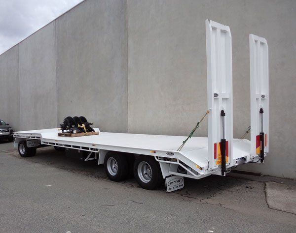 A White Flatbed Trailer Is Parked in Front of A Building — Welshpool, WA — PTE Group Pty Ltd