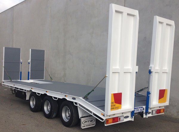A Flatbed Trailer Is Parked in Front of A Concrete Wall — Welshpool, WA — PTE Group Pty Ltd