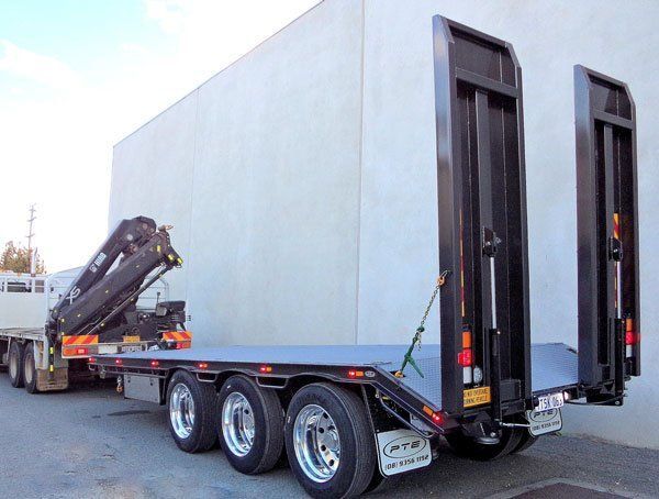 A Flatbed Truck with A Crane on The Back Is Parked in Front of A Building — Welshpool, WA — PTE Group Pty Ltd