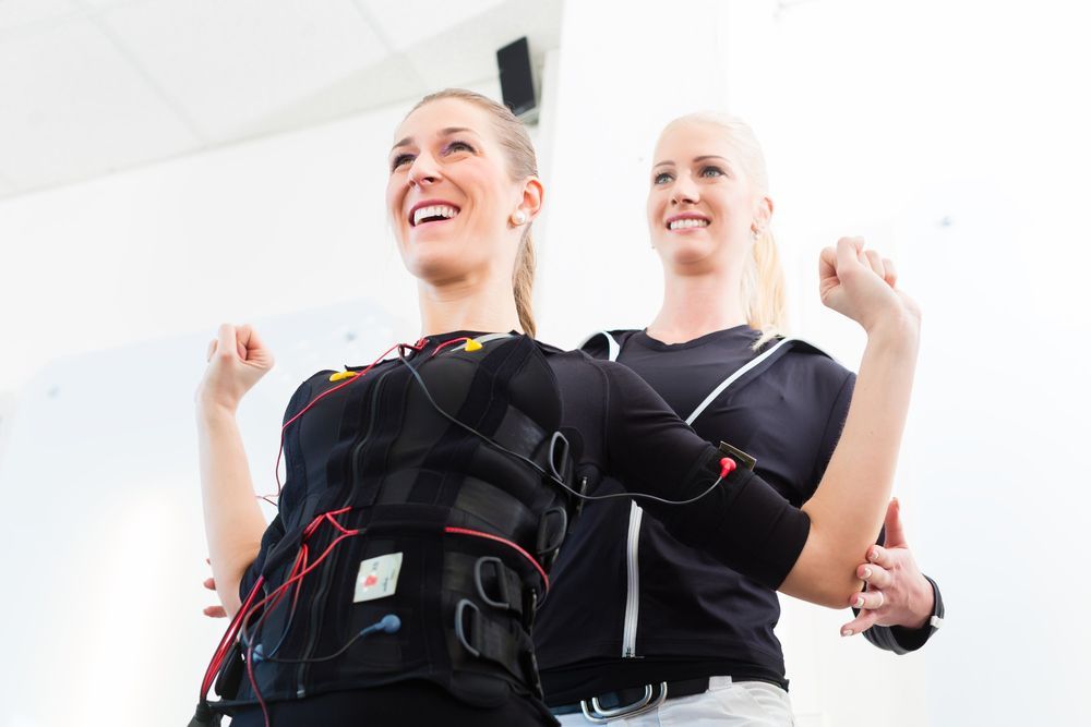 Two Women Are Standing Next To Each Other In A Gym — Caves Coastal Physiotherapy in Lake Macquarie, NSW