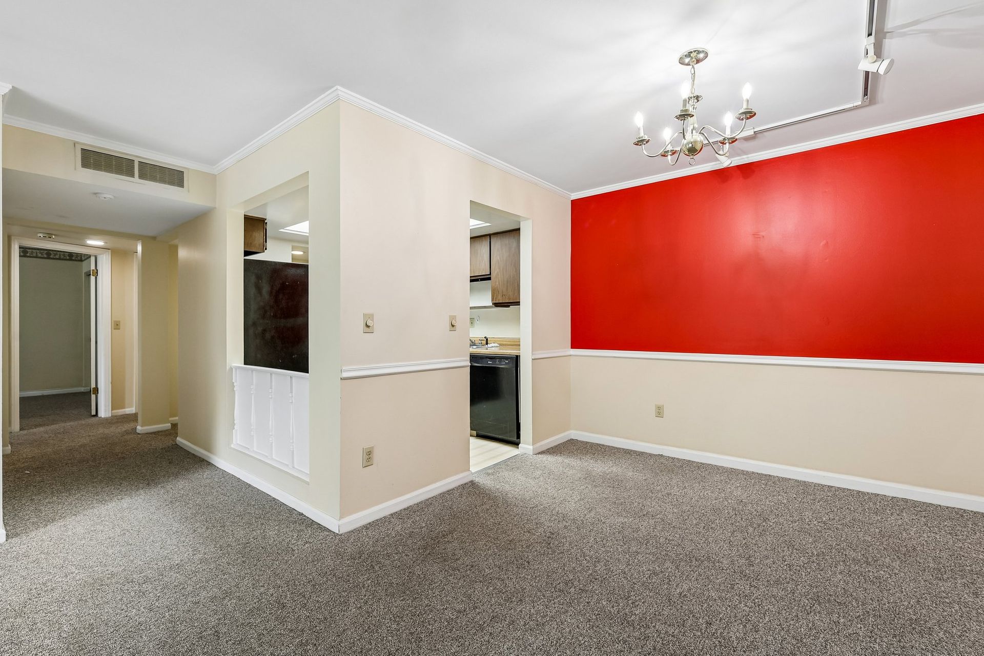 Photo of a dining area with a hallway in the background and kitchen in the middleground