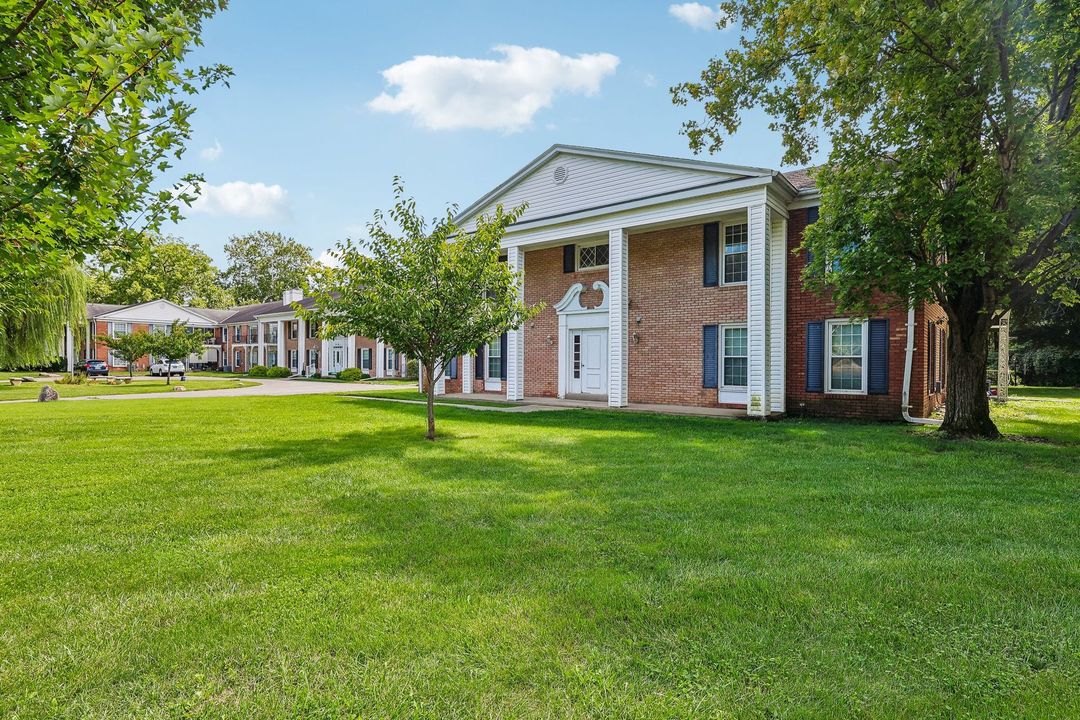 Photo of an apartment building with a large surrounding yard