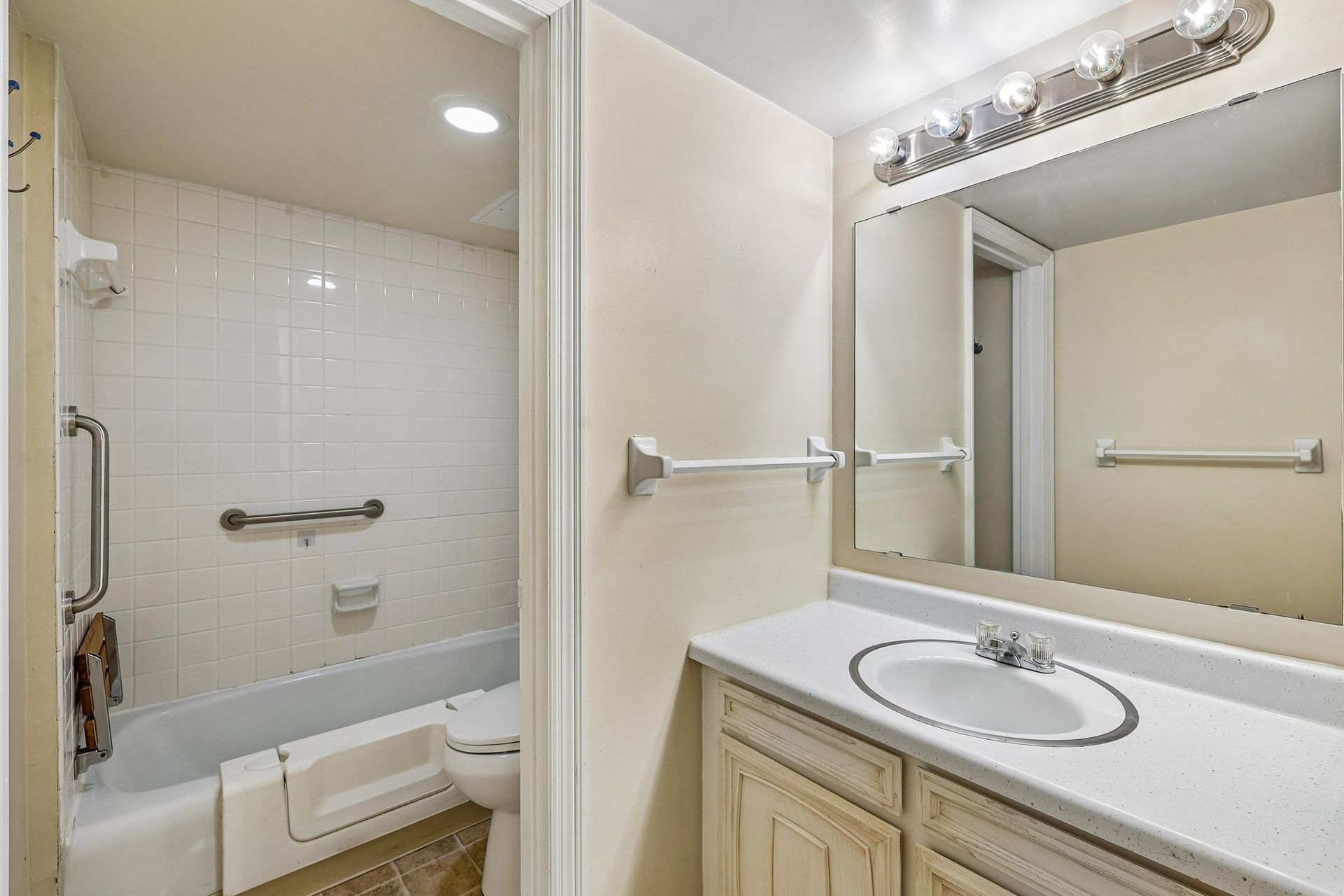 Photo of a bathroom with a separate entrance leading to a toilet next to a bathtub/shower combination
