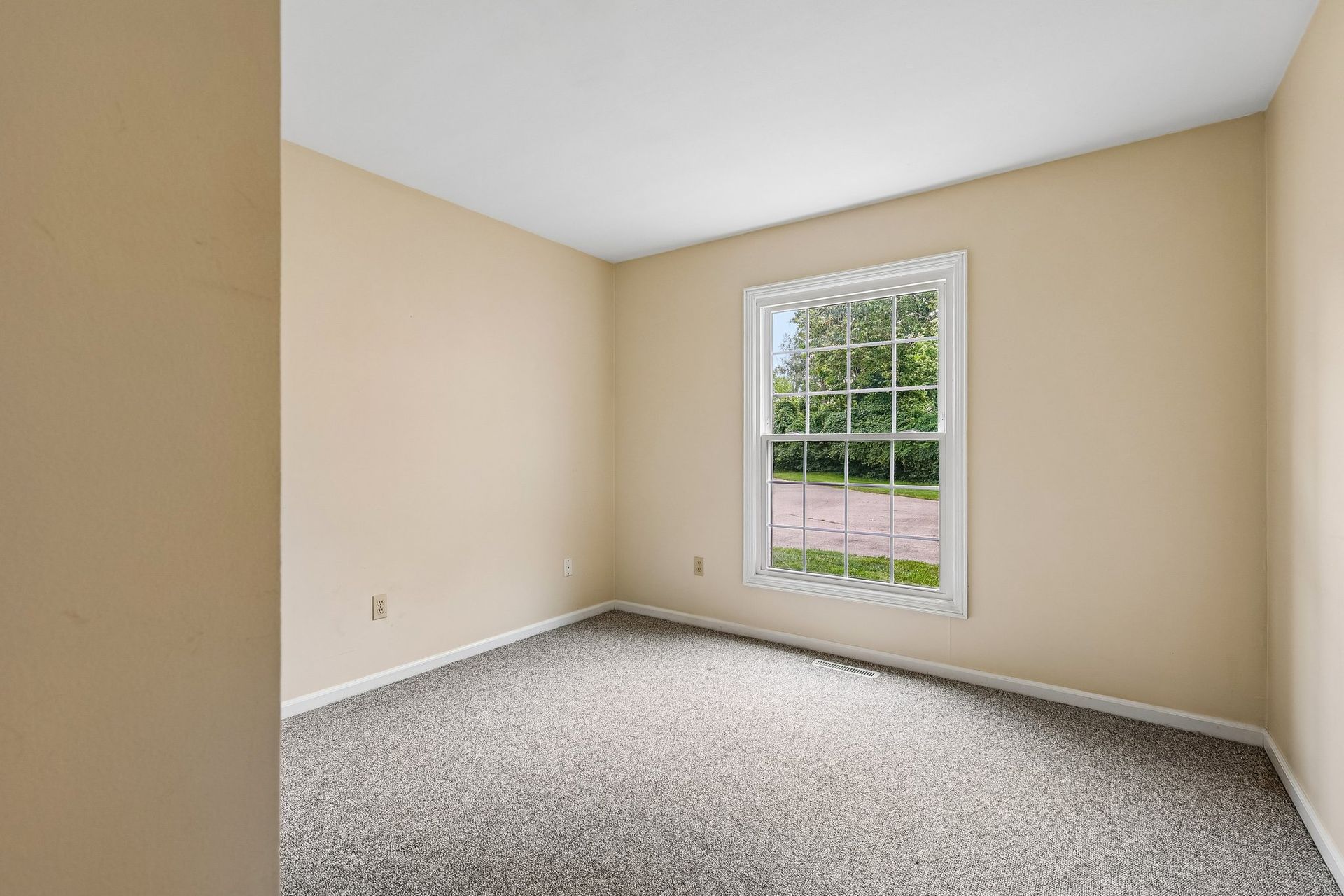 Photo of a bedroom with a very tall window that allows for plenty of natural light