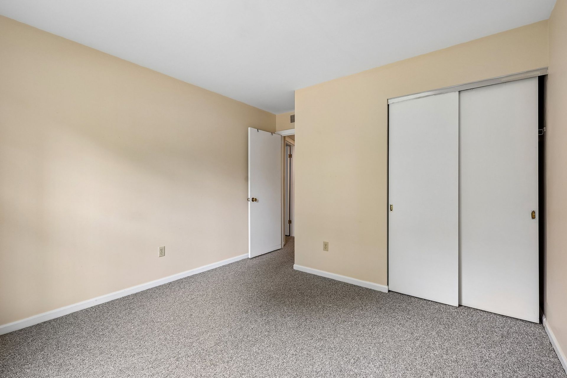 Photo of an interior bedroom with dual-closet doors