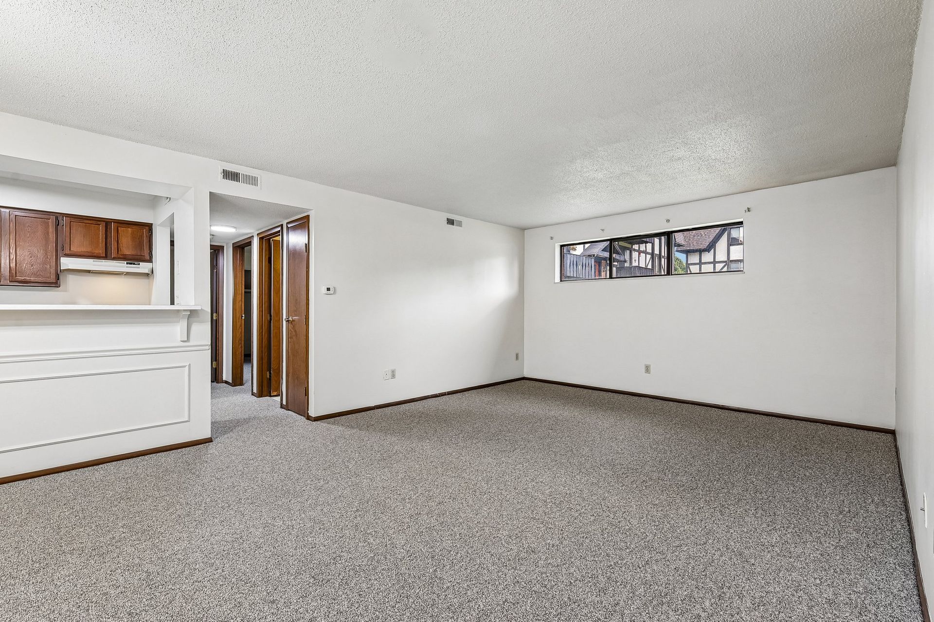 Photo of a large living room with the hallway in the background