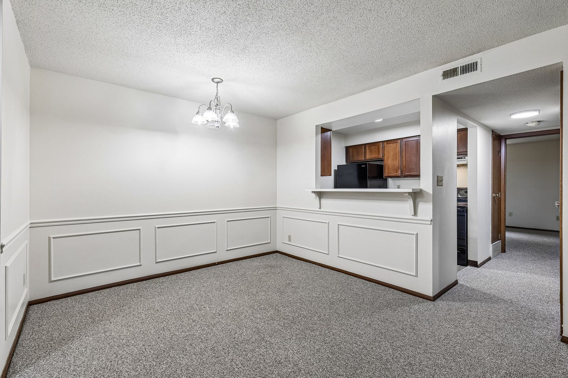 Photo of a dining area with the kitchen in the background