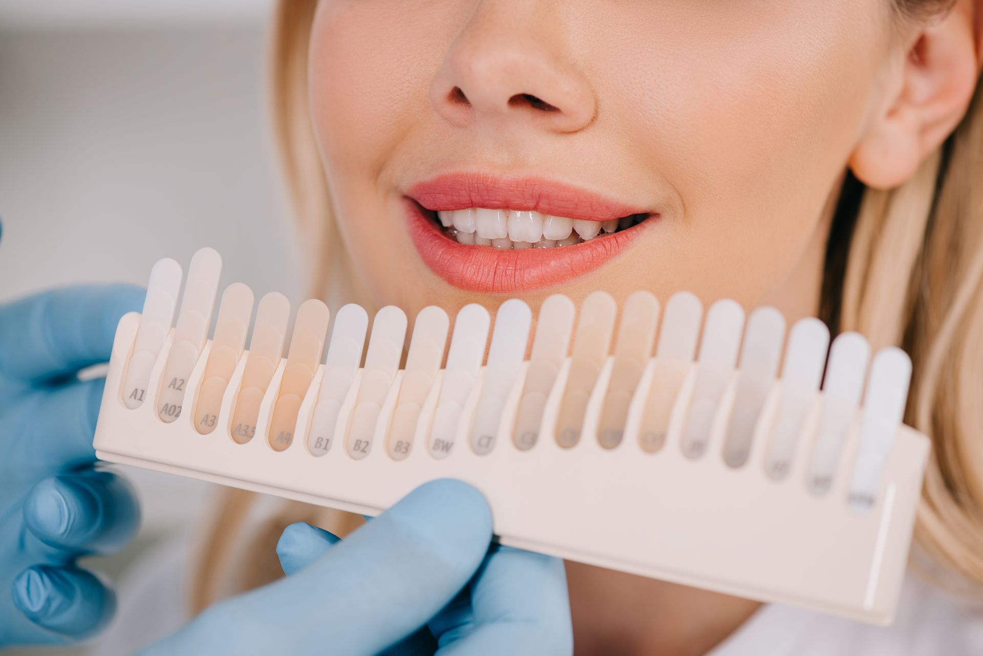 A woman is getting her teeth whitened by a dentist.