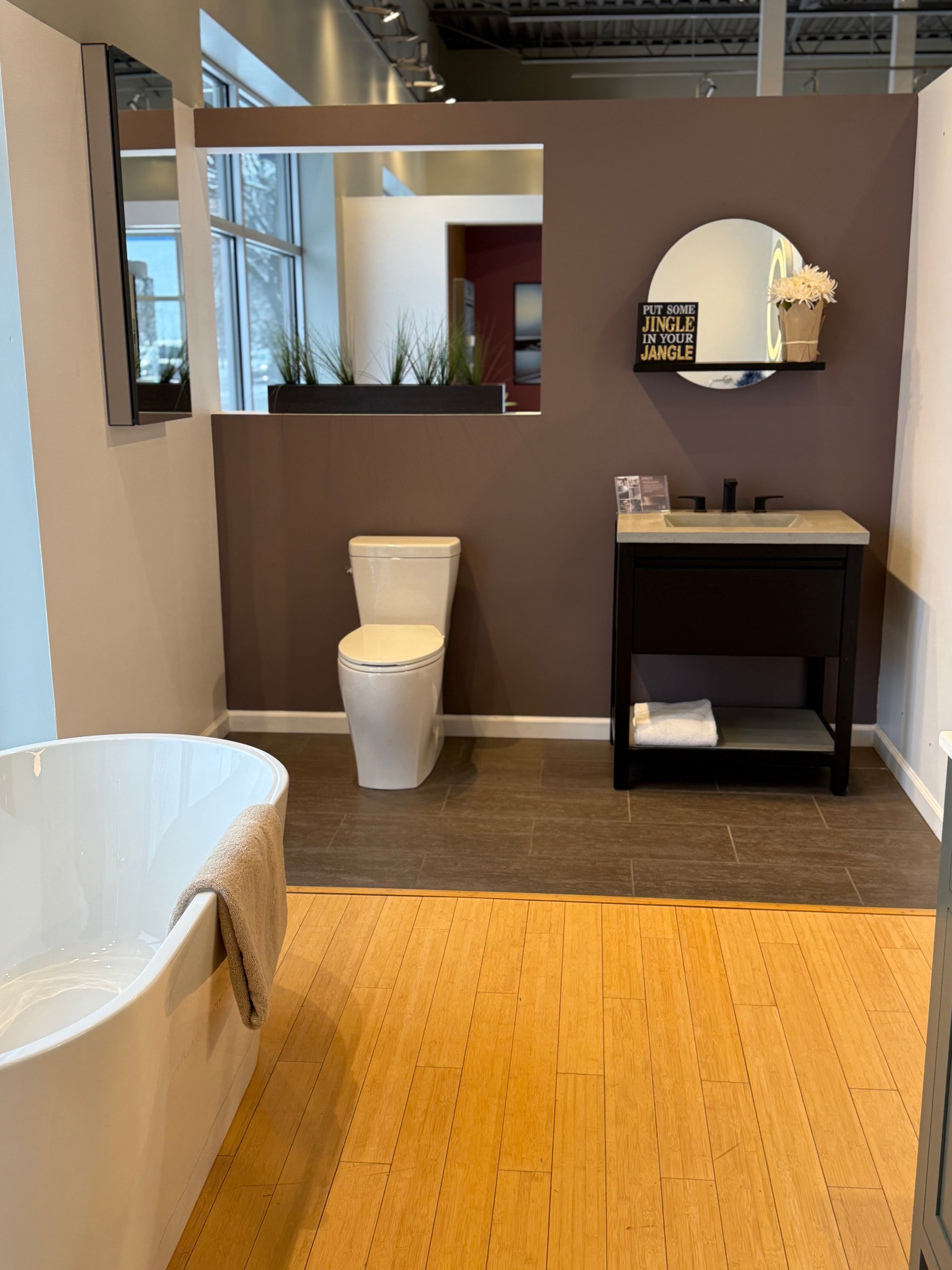 Bathroom display with toilet, vanity, and bathtub; purple and white color scheme.