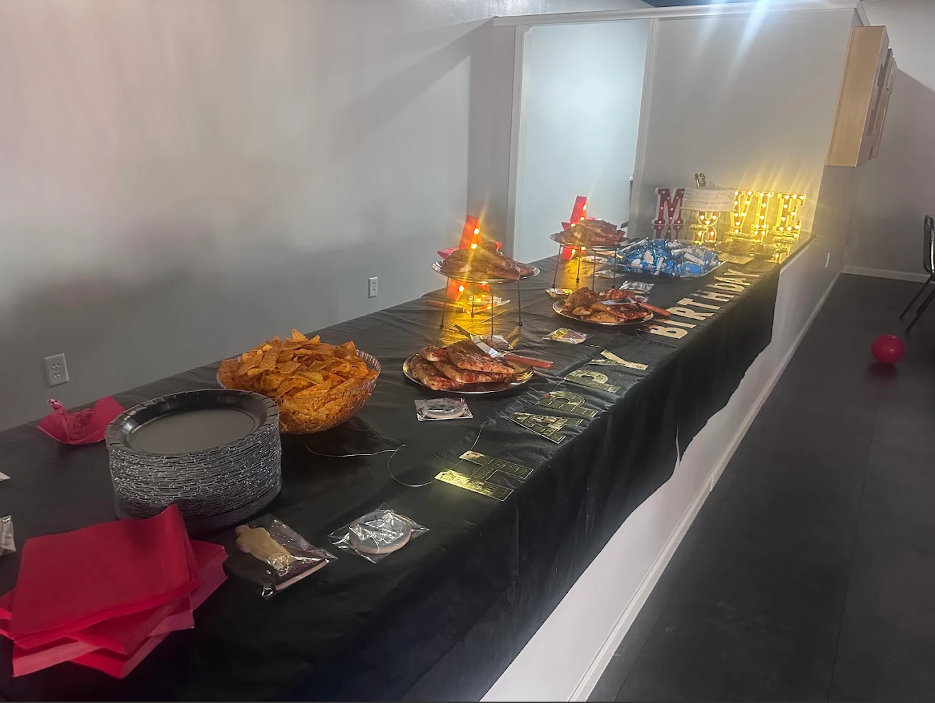 Buffet table with assorted dishes and decorative centerpieces on a black tablecloth in a banquet hall