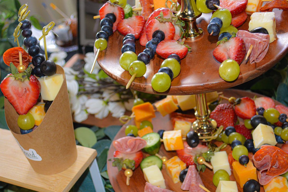 Colorful fruit and candy skewers arranged on tiered trays at a buffet display