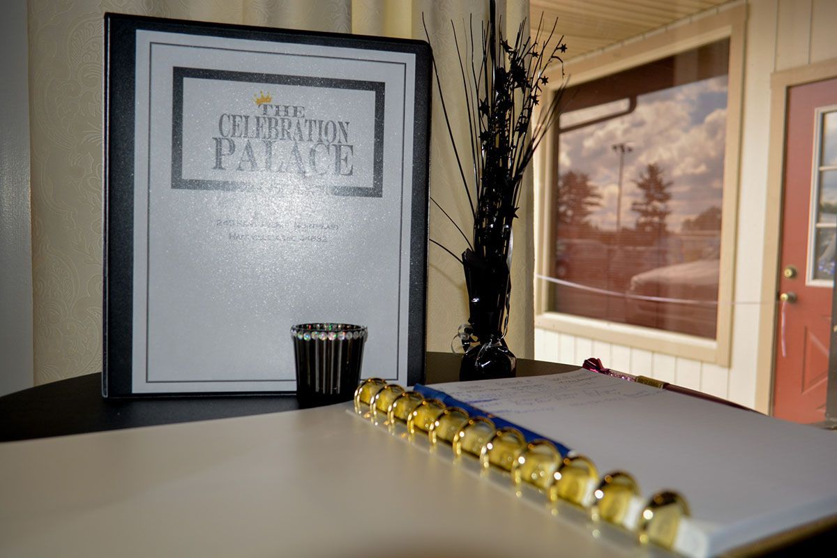 Framed poster and vase on a table beside a window, with a row of gold beads in the foreground