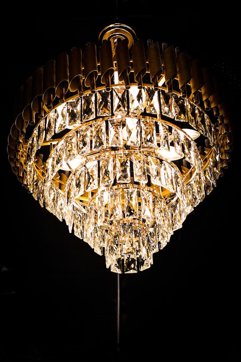 Gold crystal chandelier glowing against a black background