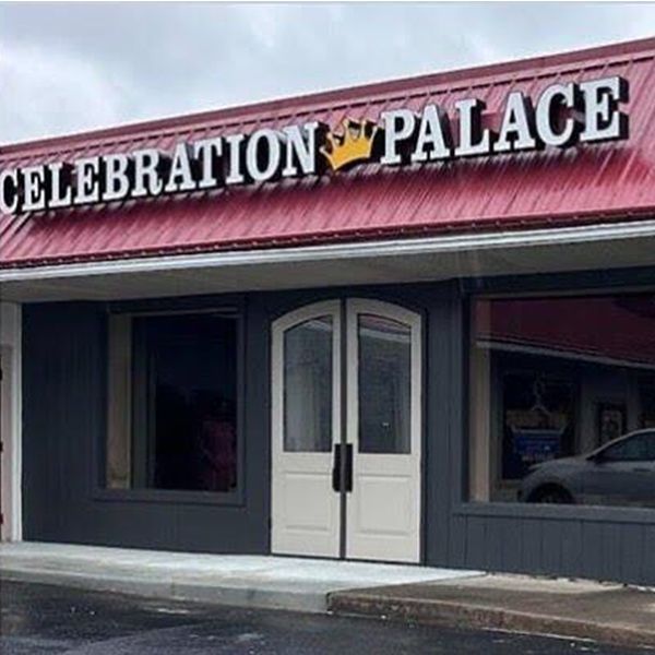 Storefront with a “Celebration Palace” sign above double white doors and dark windows