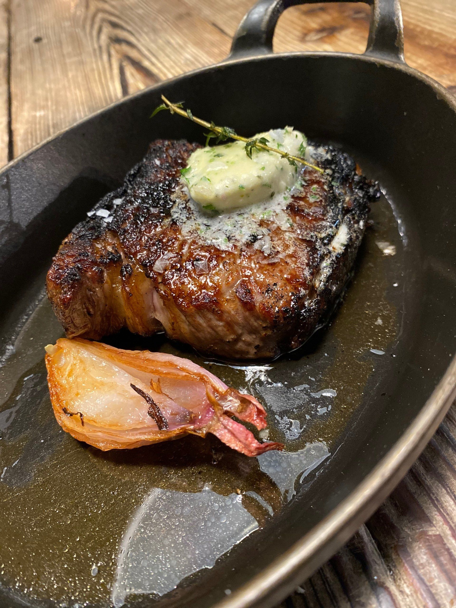 a steak in a pan with butter on top