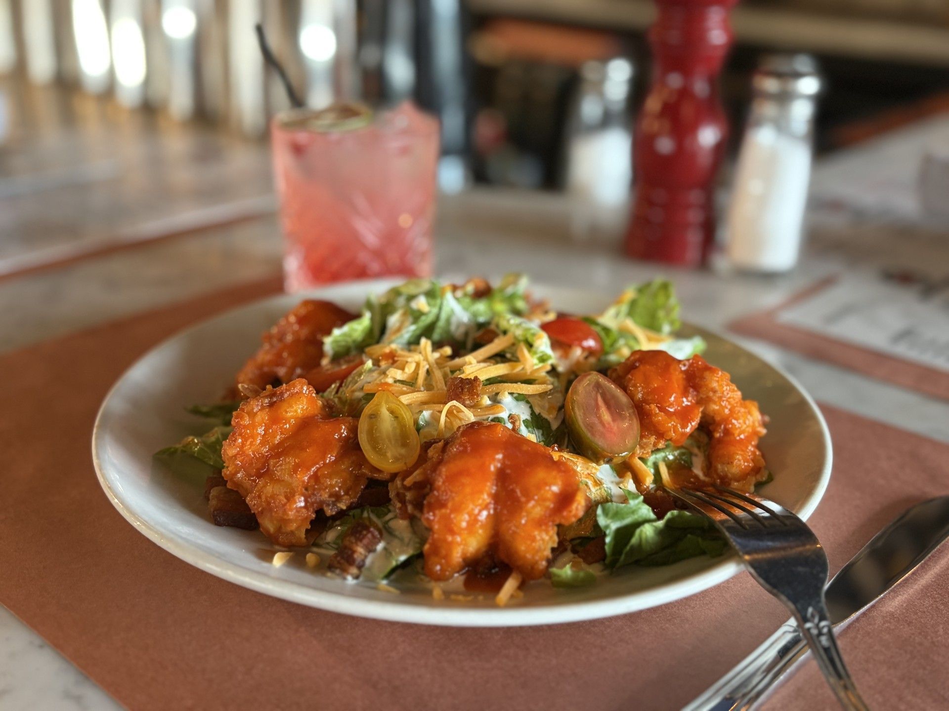 Hand breaded shrimp tossed in our special buffalo sauce, served on a bed of lettuce, topped with shredded cheddar cheese, bacon crumbles, cherry tomatoes
