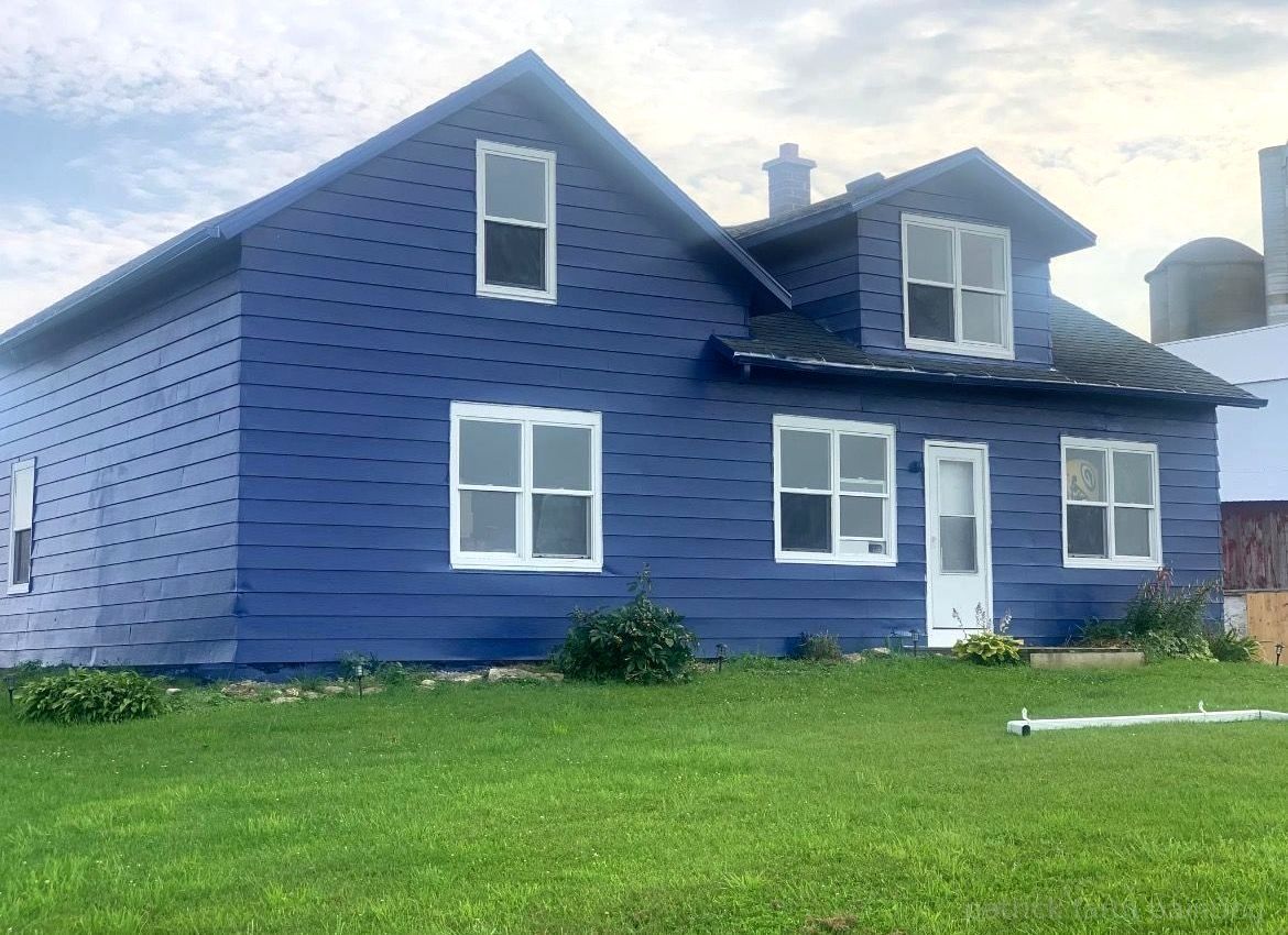Barn painting services completed by Patrick Farm Painting in Buffalo, New York. This image shows a beautifully restored farm building surrounded by open countryside and fresh landscaping. The siding and exterior surfaces appear clean, professionally coated, and vibrant under natural outdoor lighting. Experienced barn painters from Patrick Farm Painting, the trusted farm painting guy and company that paints barns in New York, carefully transformed this rural structure while preserving its original character. The scene gives visually impaired visitors a vivid sense of the peaceful farm setting, detailed craftsmanship, and the dramatic before-and-after improvement of the barn or farmhouse exterior.