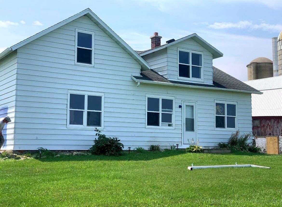 Barn painting services completed by Patrick Farm Painting in Nedrow, New York. This image displays a professionally restored barn or farmhouse surrounded by peaceful rural scenery, open land, and natural daylight. The freshly painted siding and trim showcase the craftsmanship of experienced barn painters and the trusted farm painting guy from Patrick Farm Painting, a company that paints barns in New York. The structure appears clean, durable, and revitalized with smooth exterior finishes and vibrant color restoration. This vivid description helps visually impaired website visitors imagine the countryside setting, the scale of the agricultural building, and the detailed improvements made during the farm painting project.