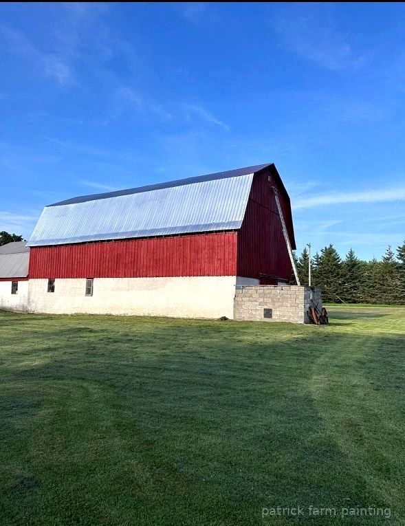 Professional barn painting services by Patrick Farm Painting in Rochester, New York. This image shows a freshly painted rural farm structure with vivid colors, clean lines, and a peaceful countryside setting. The photo highlights the craftsmanship of experienced barn painters and the detailed exterior work completed by the farm painting guy from Patrick Farm Painting, a company that paints barns in New York. The scene includes natural lighting, farm surroundings, and restored siding designed to help visually impaired website visitors imagine the full transformation.