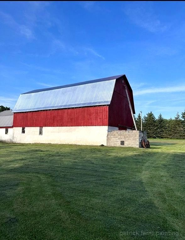Barn painting services by Patrick Farm Painting in Rome, New York. This image showcases a professionally restored barn or farmhouse surrounded by open farmland, peaceful rural scenery, and natural outdoor lighting. The freshly painted siding, trim, and exterior surfaces highlight the work of experienced barn painters and the trusted farm painting guy from Patrick Farm Painting, a company that paints barns in New York. The agricultural building appears clean, durable, and revitalized with smooth finishes and vibrant color restoration. This detailed description helps visually impaired website visitors imagine the countryside setting, the scale of the structure, and the dramatic transformation completed during the barn painting project.