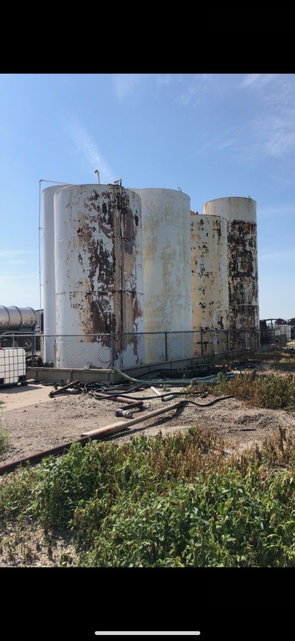 Image of the same storage tanks, but before the painting job. You can tell that the storage tanks are very rusty and in desperate need of a painting job. 