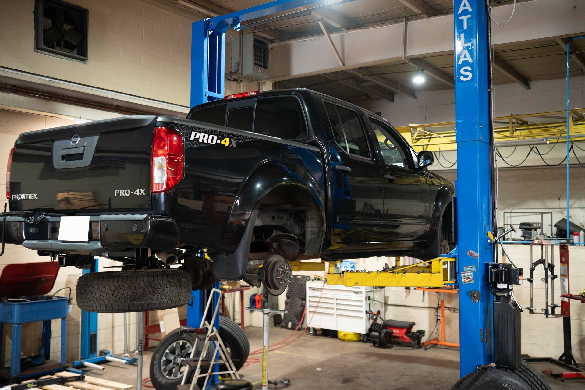 Black Pickup Truck On Blue Auto Lift | Justice Off Road