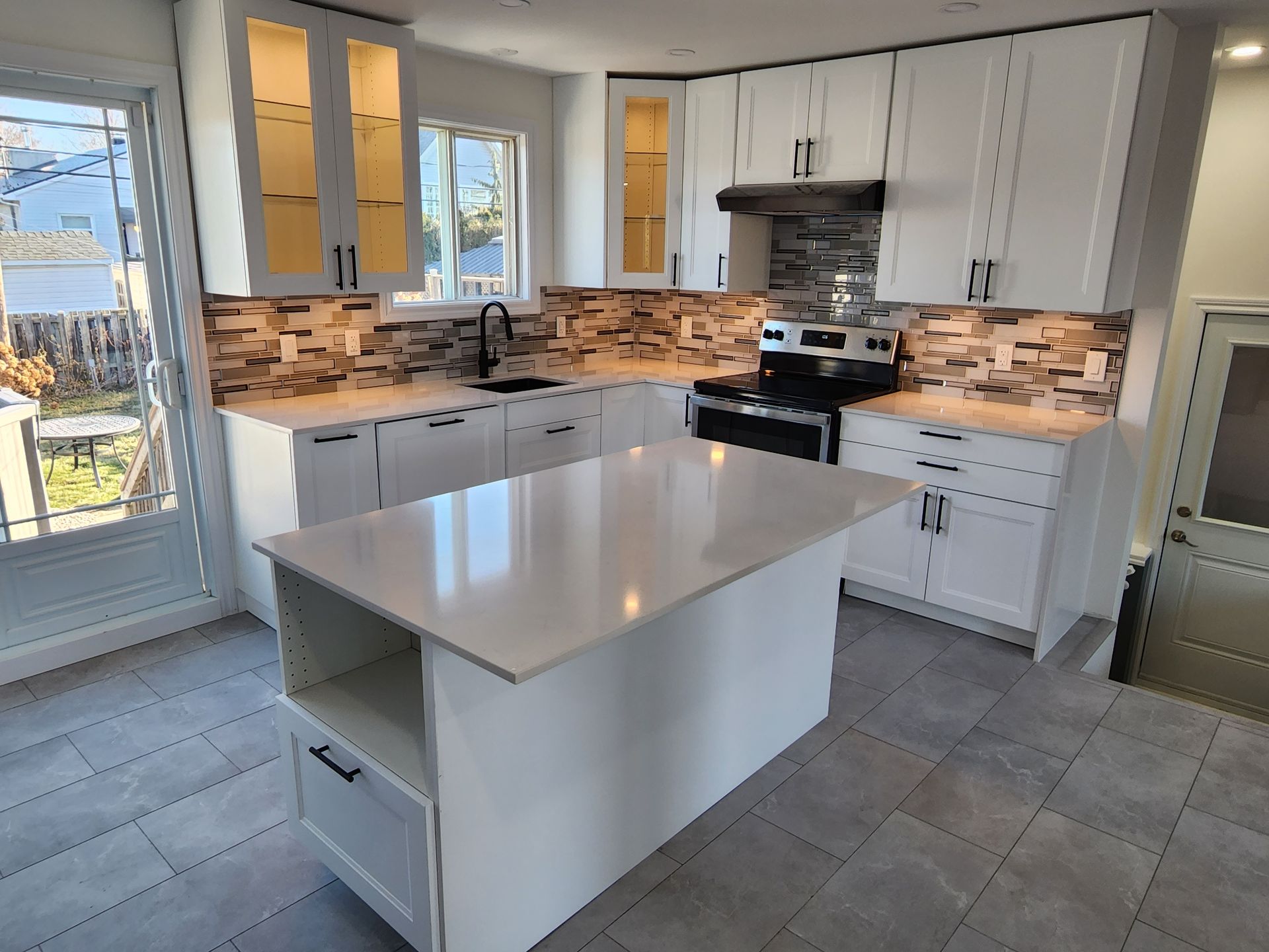 A kitchen with white cabinets and a large island in the middle.
