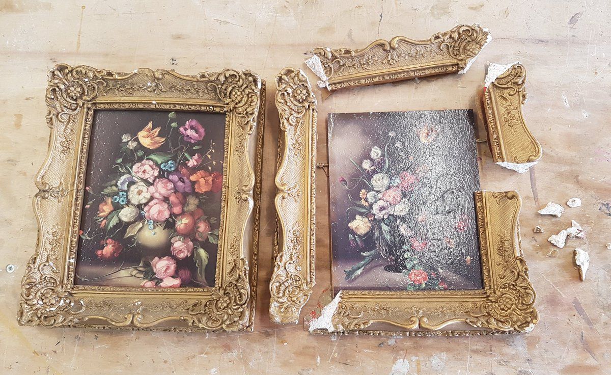 two framed paintings side by side. The frame on the right is broken into pieces; the painting to the left is all intact.