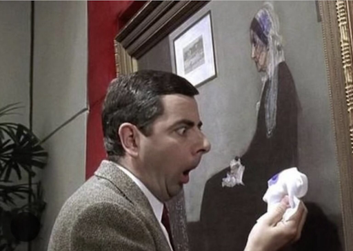 Mr. Bean attempting to clean a painting himself, with a tissue in hand and a look of shock and horro
